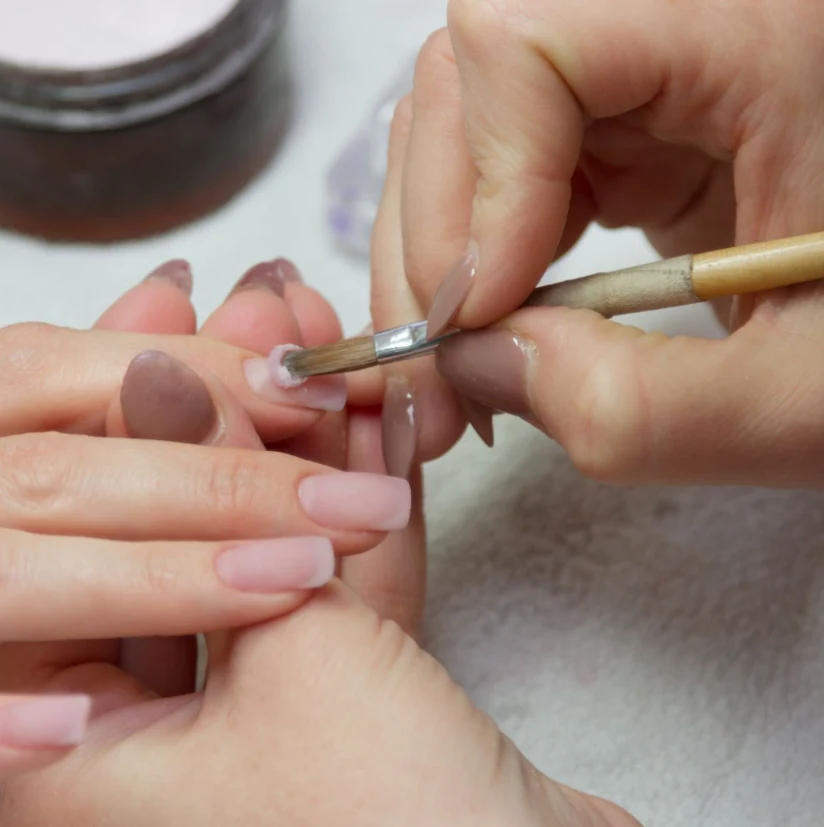 Nail extensions "Nail technician applying acrylic extensions to a client
